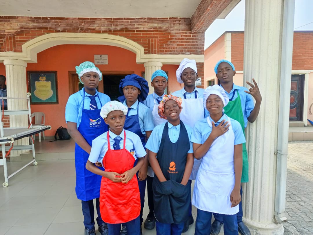 Pedrisi students in chef aprons and hats on campus